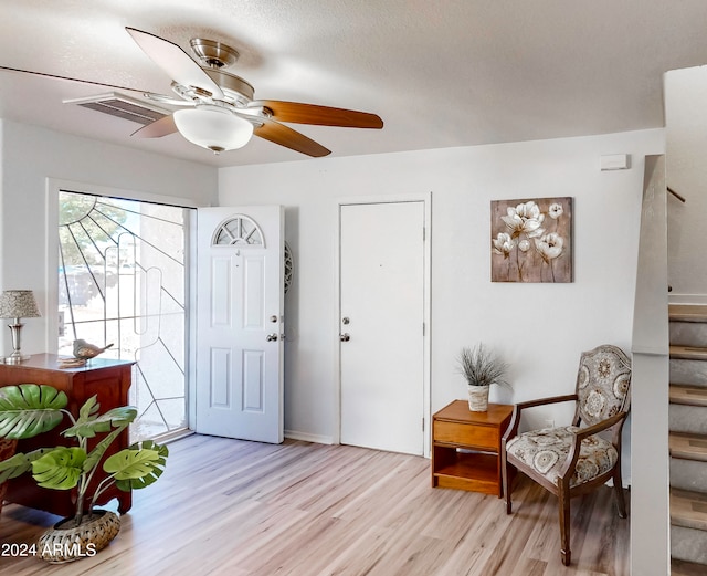 entryway with a textured ceiling, light hardwood / wood-style flooring, and ceiling fan