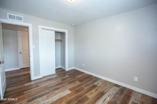 unfurnished bedroom with dark hardwood / wood-style floors and a closet