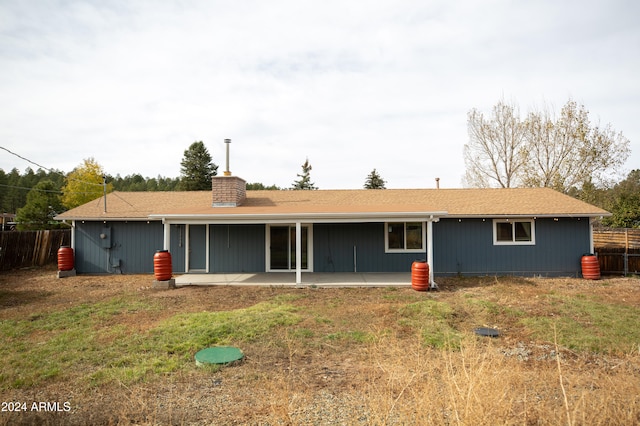 rear view of house featuring a patio and a lawn