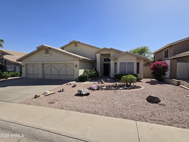 view of front facade with a garage, concrete driveway, stucco siding, and fence