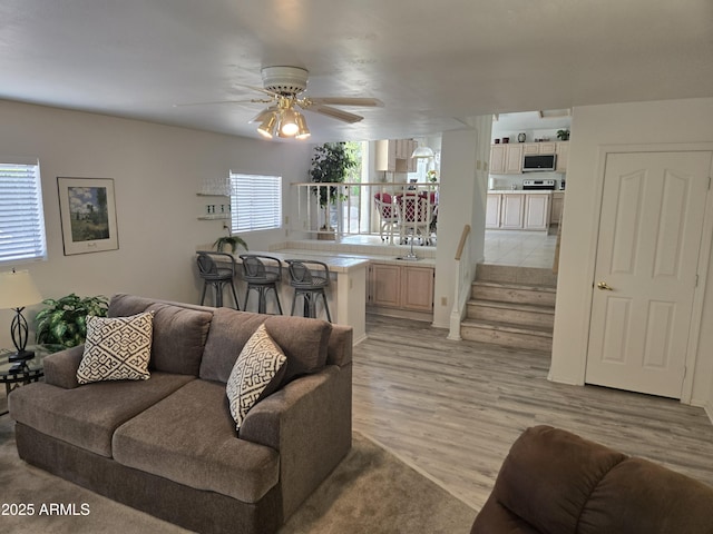 living room featuring a ceiling fan and light wood-style floors