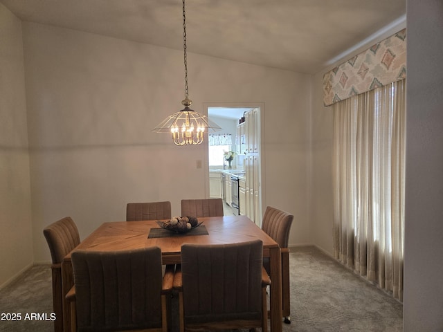 dining room with carpet, lofted ceiling, a chandelier, and baseboards