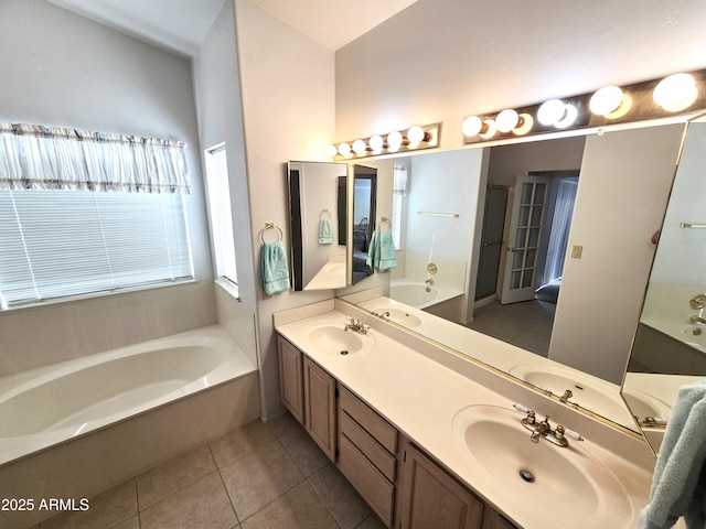 full bath with a garden tub, tile patterned floors, and double vanity
