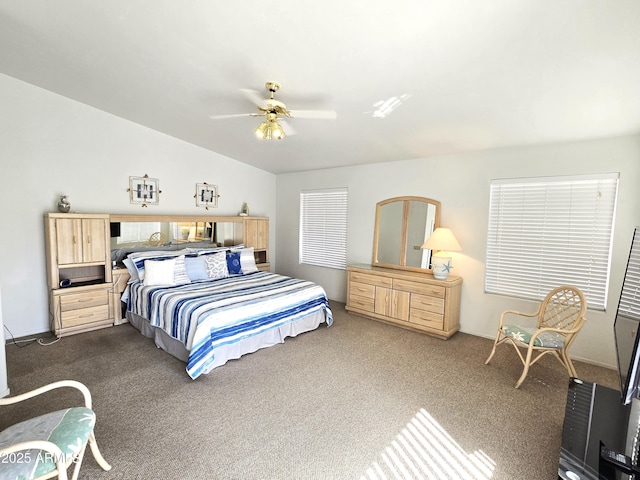 bedroom with vaulted ceiling, dark colored carpet, a ceiling fan, and baseboards