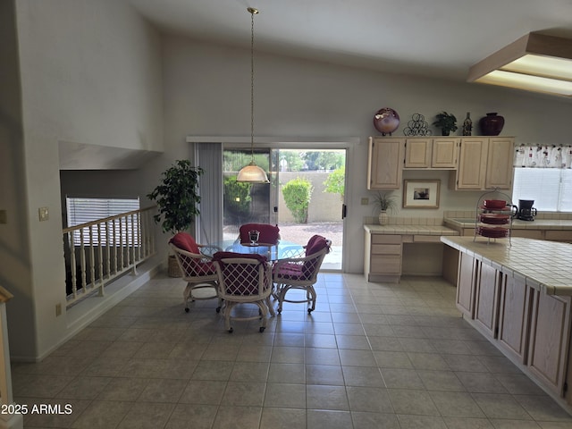 dining room featuring light tile patterned flooring, plenty of natural light, and high vaulted ceiling