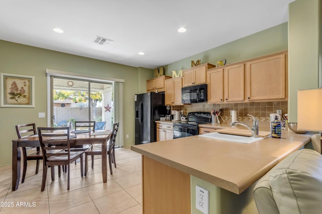 kitchen featuring light brown cabinetry, tasteful backsplash, black appliances, sink, and kitchen peninsula