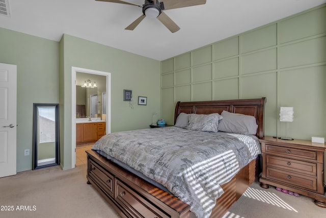 carpeted bedroom with ceiling fan and ensuite bath