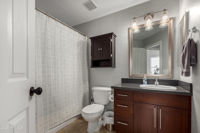 bathroom featuring tile patterned flooring, vanity, and toilet