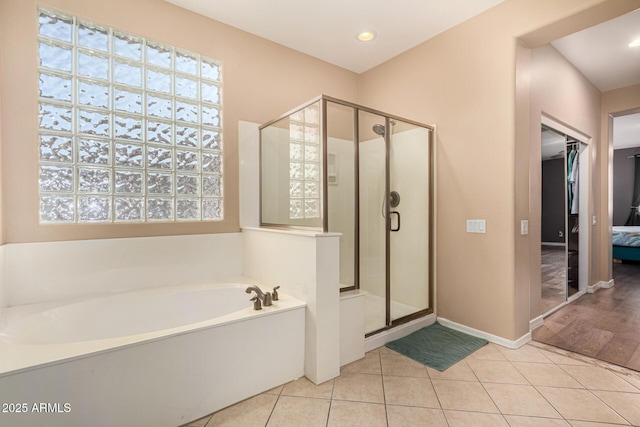 bathroom with separate shower and tub and tile patterned flooring