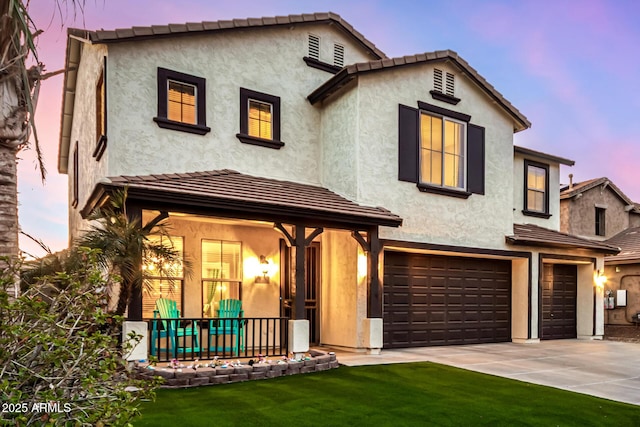 mediterranean / spanish home featuring a lawn and a garage