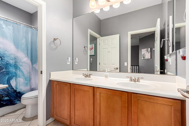 bathroom with toilet, vanity, and tile patterned floors