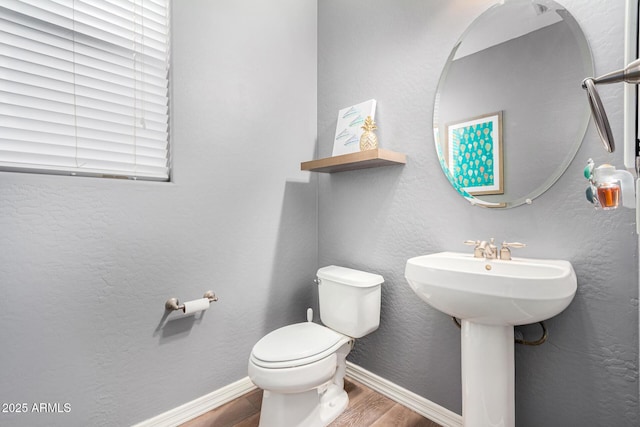 bathroom with toilet, hardwood / wood-style floors, and sink