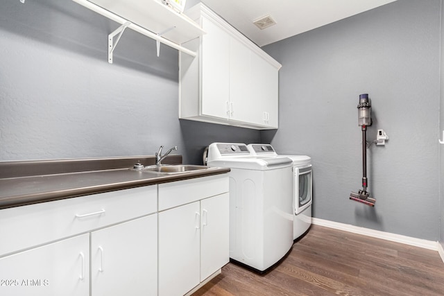 laundry room featuring washer and dryer, dark hardwood / wood-style floors, sink, and cabinets