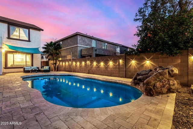 pool at dusk featuring a patio