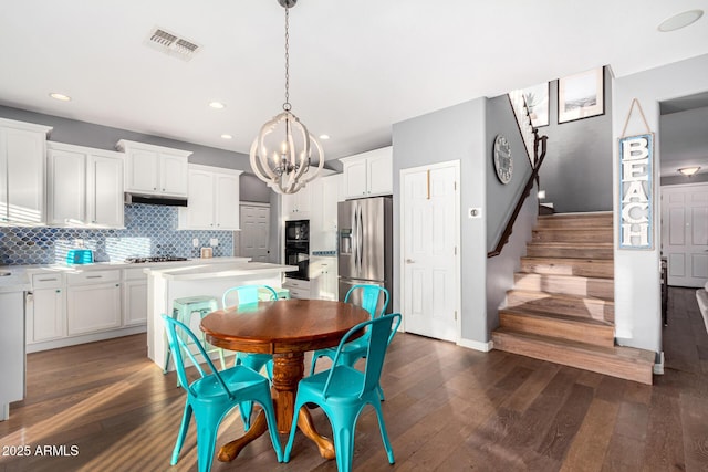 dining space featuring dark hardwood / wood-style floors and a notable chandelier