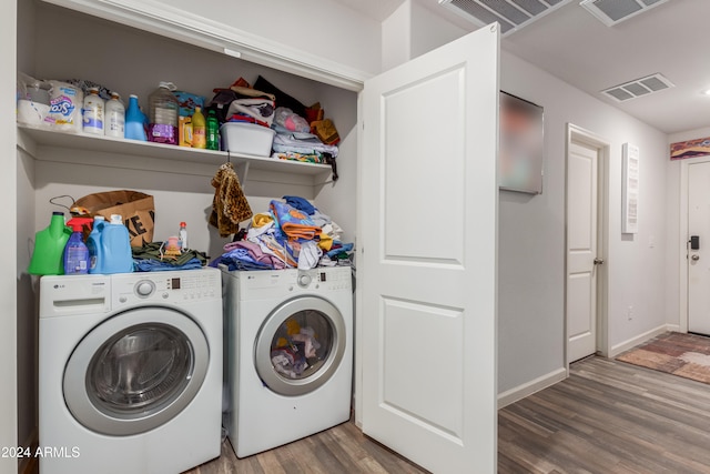 clothes washing area featuring hardwood / wood-style flooring and washing machine and dryer