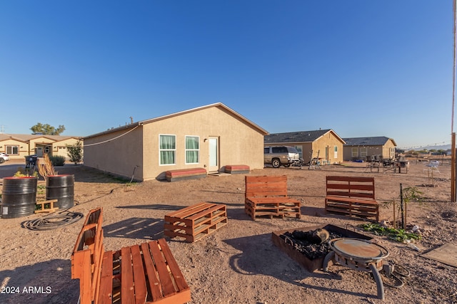 back of house featuring an outdoor fire pit