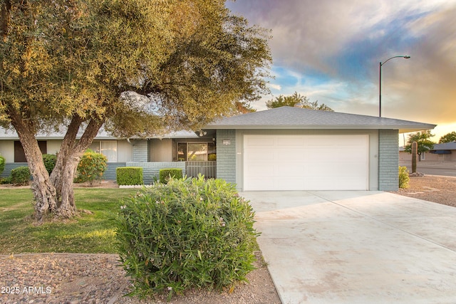 ranch-style house with brick siding, an attached garage, fence, and driveway