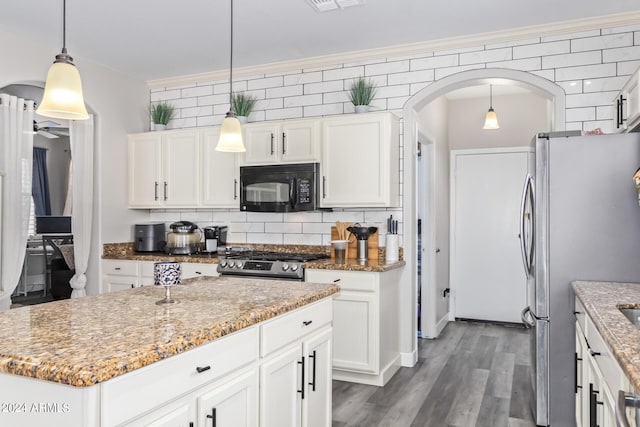 kitchen with a ceiling fan, arched walkways, white cabinetry, and appliances with stainless steel finishes