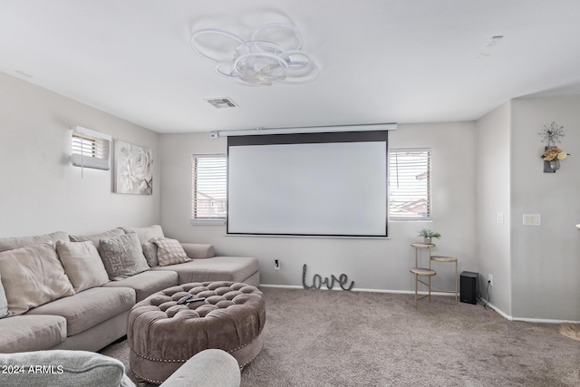 carpeted home theater with visible vents, baseboards, and a chandelier