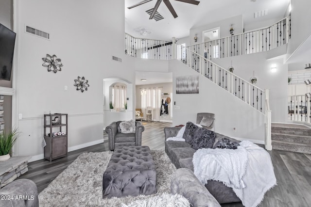 living area with visible vents, a ceiling fan, arched walkways, and wood finished floors