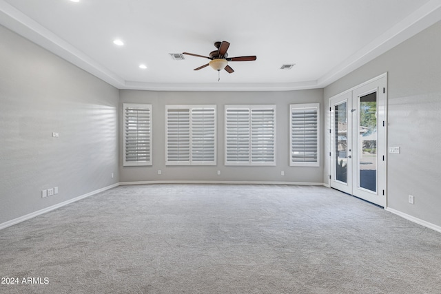 spare room with french doors, light colored carpet, and ceiling fan