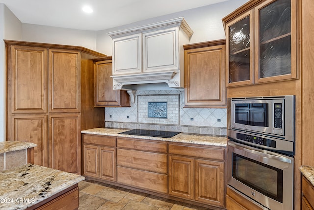 kitchen featuring stainless steel appliances, light stone countertops, and tasteful backsplash