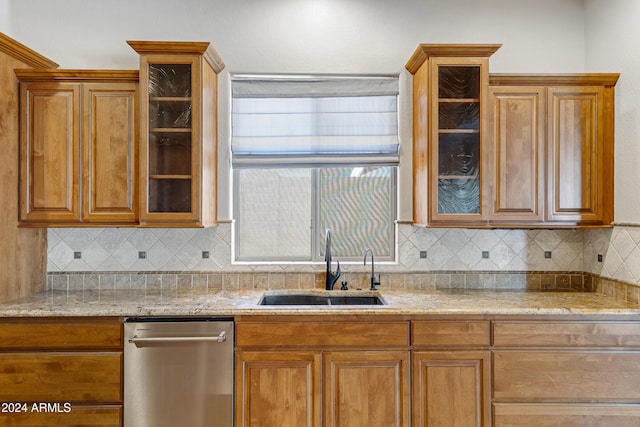 kitchen with decorative backsplash, light stone countertops, sink, and stainless steel dishwasher