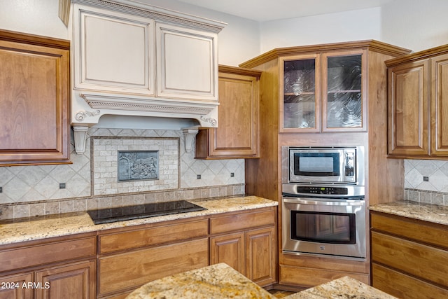 kitchen with tasteful backsplash, light stone countertops, custom range hood, and stainless steel appliances