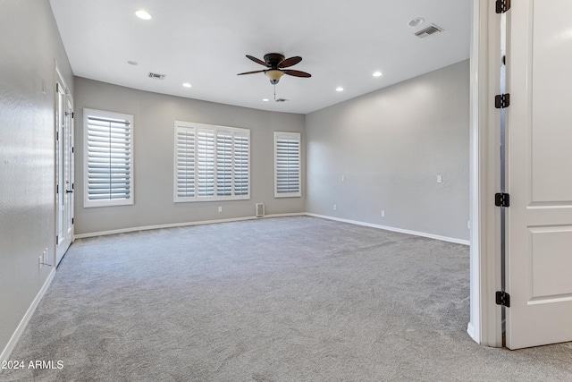 spare room with light colored carpet and ceiling fan