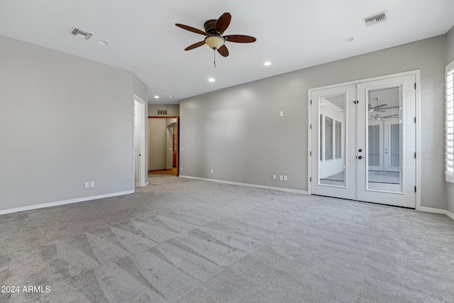 carpeted spare room with french doors and ceiling fan