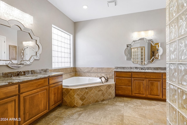 bathroom with vanity and tiled tub