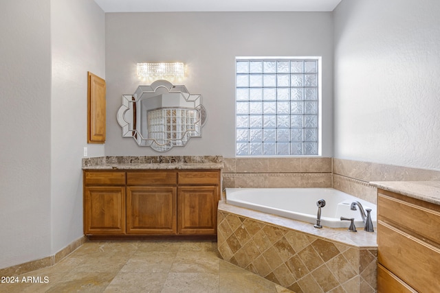 bathroom with vanity and tiled tub