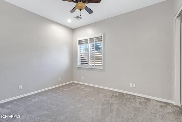 carpeted spare room with ceiling fan