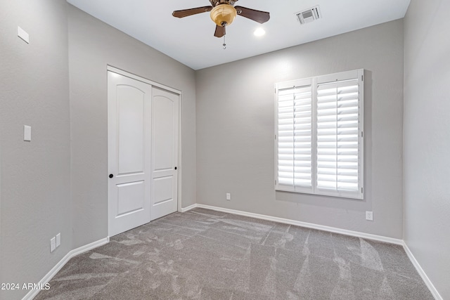 unfurnished bedroom featuring a closet, light carpet, and ceiling fan