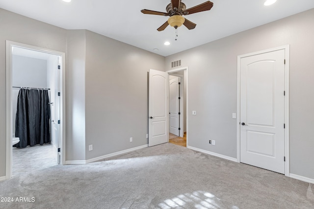 unfurnished bedroom featuring ceiling fan, light carpet, and a spacious closet