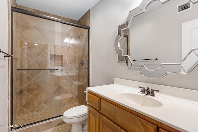 bathroom with tile patterned floors, vanity, toilet, and an enclosed shower