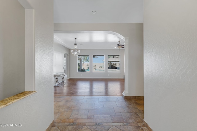 hall featuring wood-type flooring and an inviting chandelier