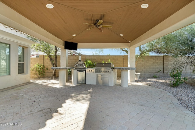 view of patio with an outdoor kitchen, area for grilling, and ceiling fan