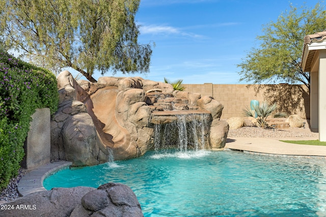 view of swimming pool with pool water feature