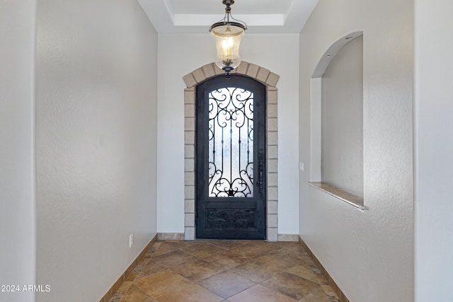 foyer entrance with a raised ceiling