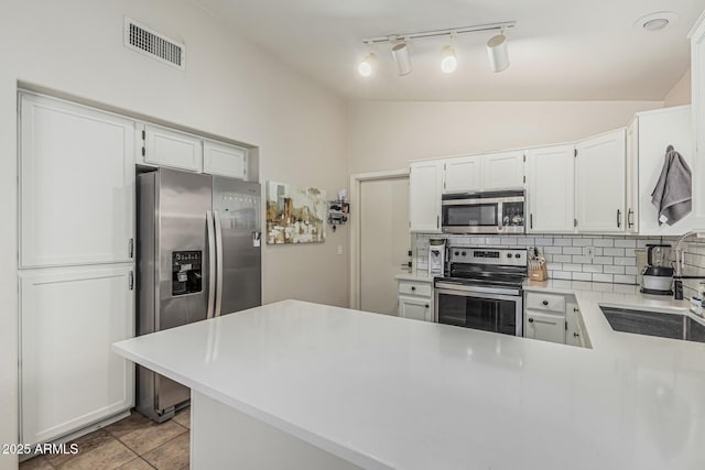 3856 E Encinas Ave, Gilbert, AZ 85234 - kitchen featuring appliances with stainless steel finishes, tasteful backsplash, light countertops, a peninsula, and track lighting