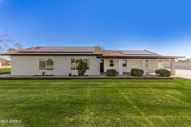 ranch-style home with a porch, a front lawn, and solar panels