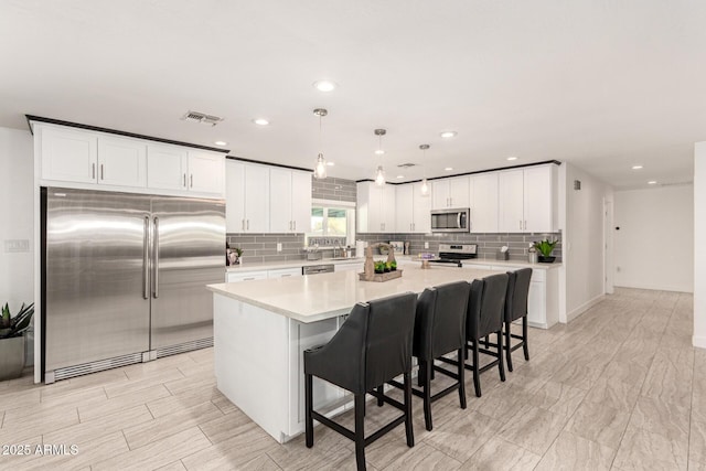 kitchen featuring hanging light fixtures, stainless steel appliances, and a kitchen island