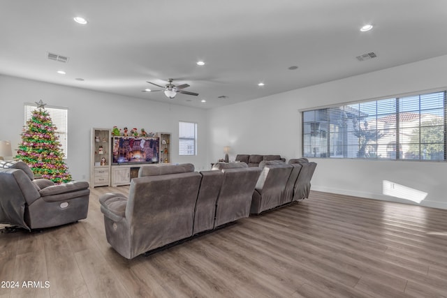 living room featuring wood-type flooring, ceiling fan, and plenty of natural light