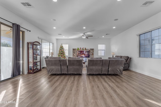 living room with plenty of natural light, ceiling fan, and light hardwood / wood-style flooring