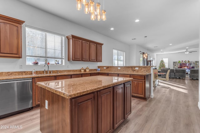 kitchen featuring hanging light fixtures, a kitchen island, sink, and stainless steel dishwasher