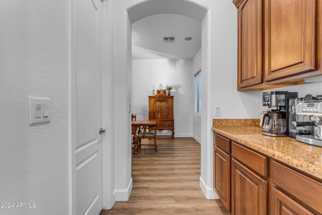 kitchen with light wood-type flooring and light stone counters