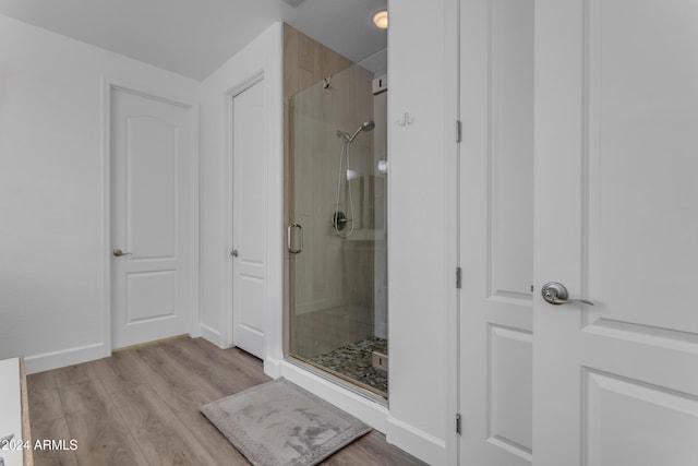 bathroom with walk in shower and hardwood / wood-style floors