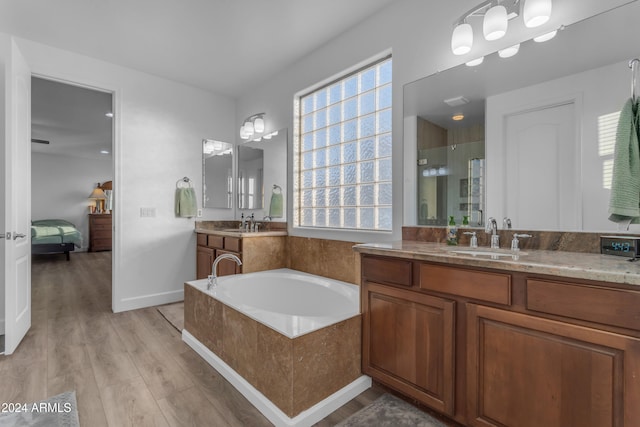 bathroom featuring vanity, hardwood / wood-style floors, and plus walk in shower